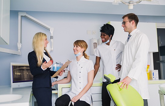front desk manager talking to the other dental staff about cost efficiency