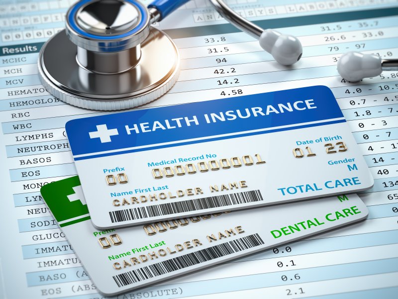 medical insurance card and dental insurance care on top of a bill