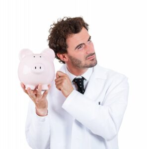 dentist holding and knocking on a piggy bank