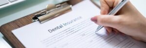 dental insurance form with hand holding a pen