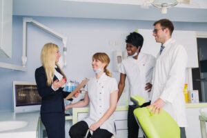 happy dental team talking in a dental chair