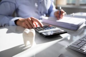 dental office calculating cost with paperwork on the desk